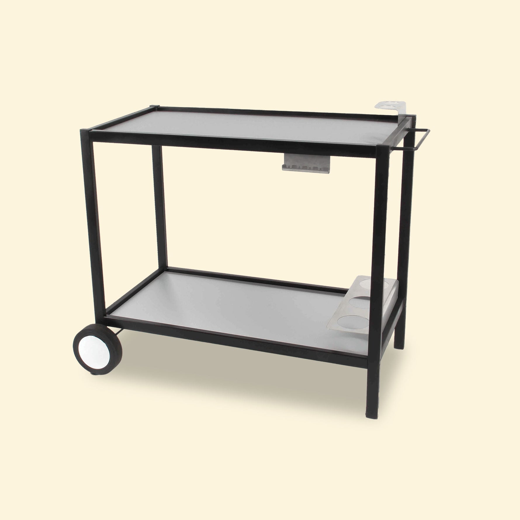 Chariot de plancha en métal noir avec plateaux en inox, doté de deux roues arrière, d’un porte-ustensiles latéral et d’un support à bouteilles intégré, présenté sur fond uni clair.