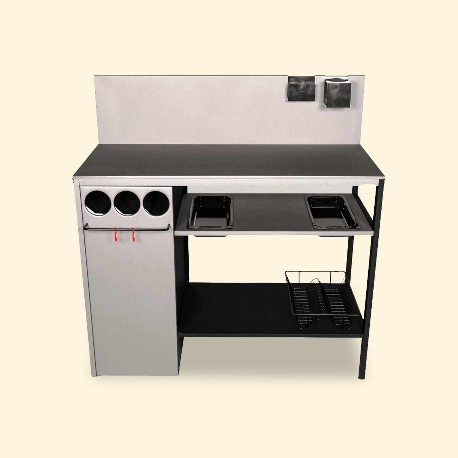 Module de cuisine extérieure complet avec crédence, rangements cylindriques, barre porte-ustensiles, bacs intégrés et panier de rangement inférieur, présenté de face sur fond uni clair.