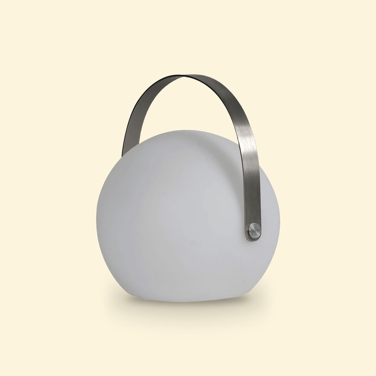 Lampe ronde d’extérieur solaire éteinte, avec anse métallique arquée, posée sur un fond beige clair.
