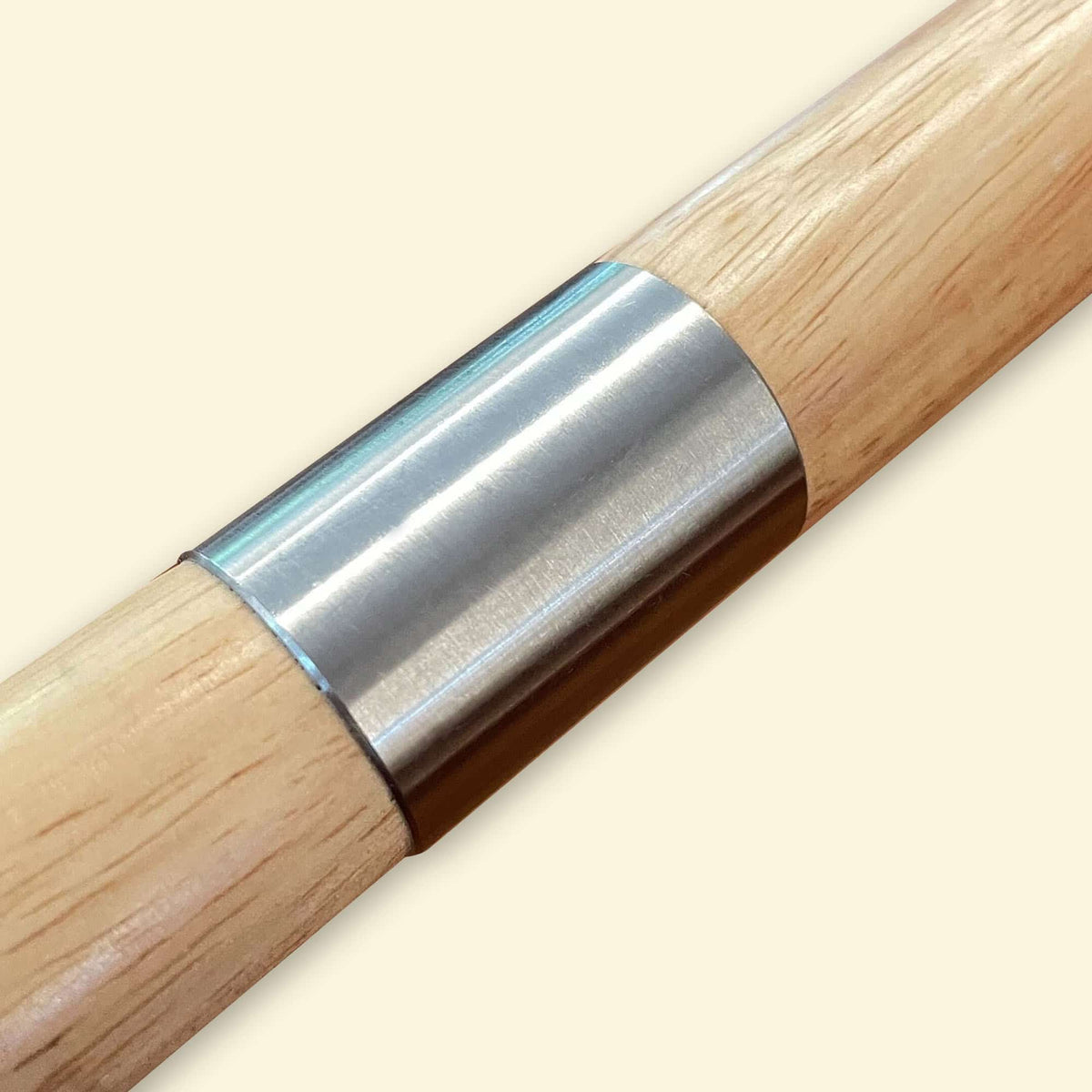 Gros plan sur le manche en bois de la pelle à pizza XL, avec son embout métallique cylindrique en inox fixé à l’extrémité.