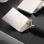 Spatules de cuisine en inox avec manche noir, posées sur un plan de travail sombre, montrées en gros plan.