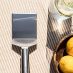 Spatule classique Vivaplancha posée près d'un verre et d'un bol de citrons